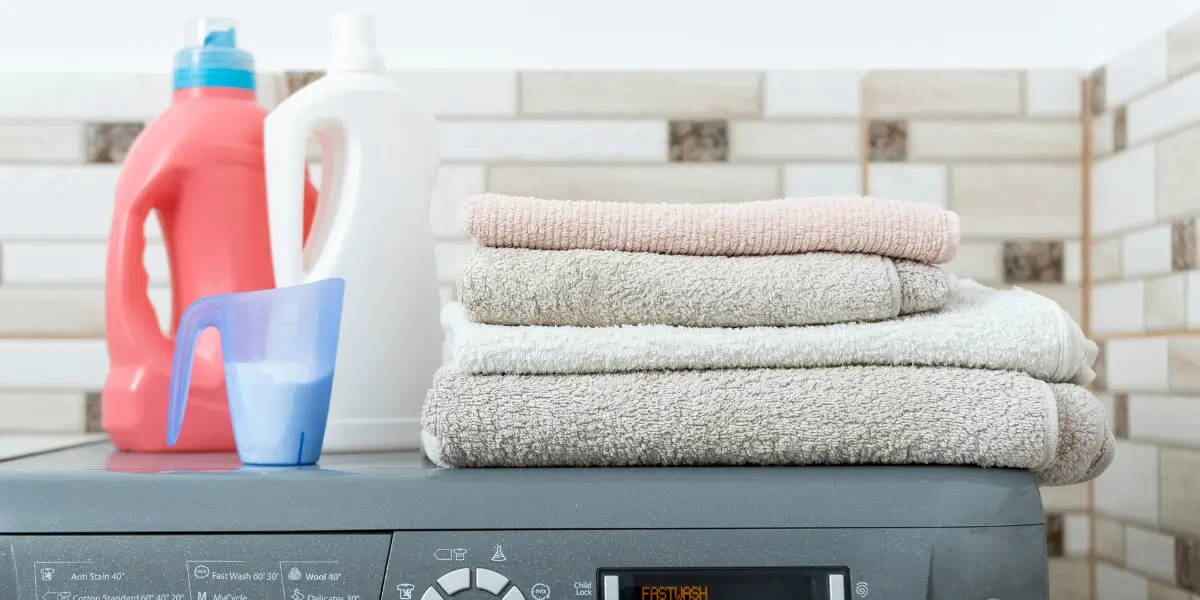 detergents and laundry above a washing machine