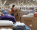 man standing between stacks of fabric and boxes